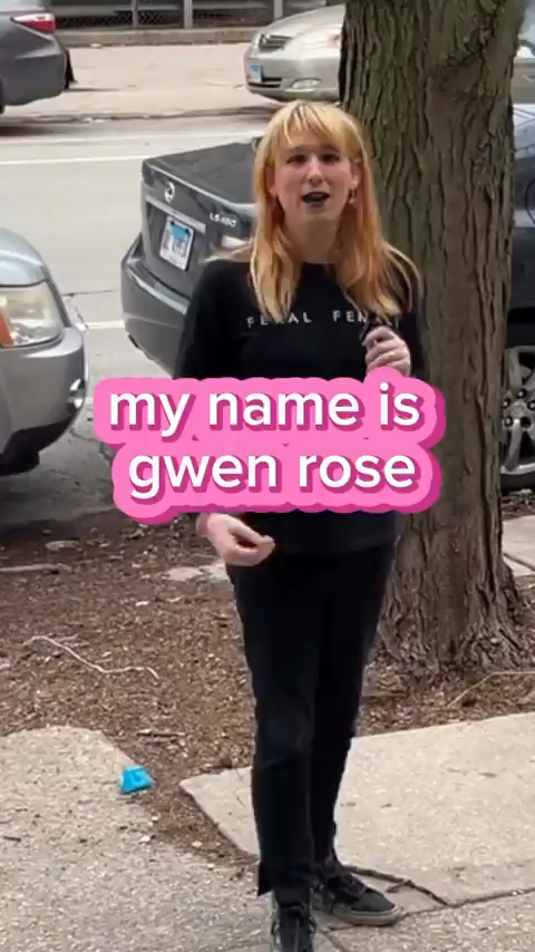 image of blonde trans woman standing on the sidewalk speaking to the camera
